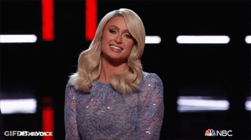 A Woman In A Blue Sequined Dress Is Waving At The Camera On Nbc 'S The Voice Show GIF