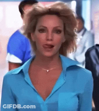 A Woman In A Blue Shirt And Necklace Is Talking To Someone GIF