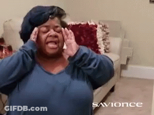 A Woman In A Blue Shirt Is Covering Her Ears With Her Hands In A Living Room With The Words Savonce On The Bottom GIF