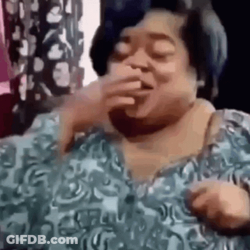 A Woman In A Blue Shirt Is Covering Her Mouth With Her Hand And Laughing . GIF