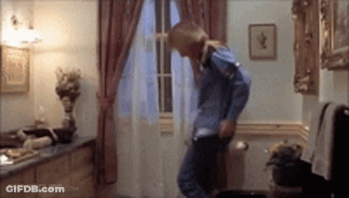 A Woman In A Blue Shirt Is Dancing In A Room With Movie Clips.com On The Bottom Of The Screen . GIF