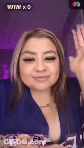 A Woman In A Blue Shirt Is Giving A Thumbs Up Sign GIF