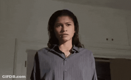 A Woman In A Blue Shirt Is Holding A Knife In Her Hand . GIF