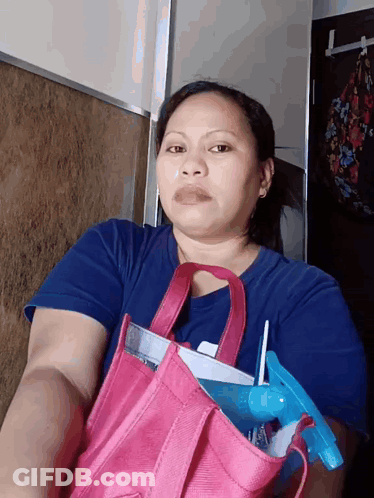 A Woman In A Blue Shirt Is Holding A Pink Bag With A Spray Bottle In It GIF