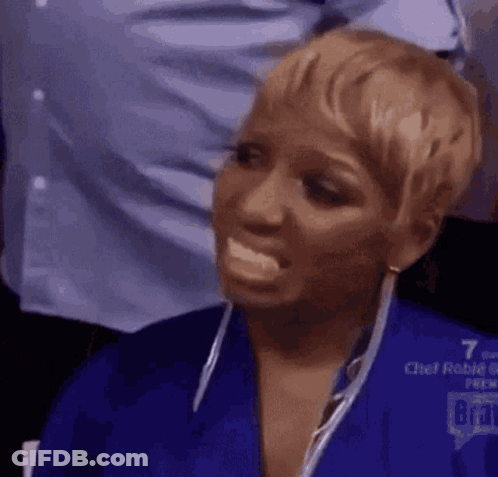 A Woman In A Blue Shirt Is Making A Funny Face With Her Mouth Open . GIF