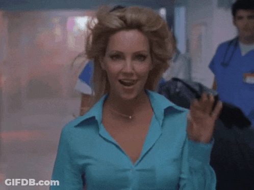 A Woman In A Blue Shirt Is Pointing Her Finger At The Camera GIF
