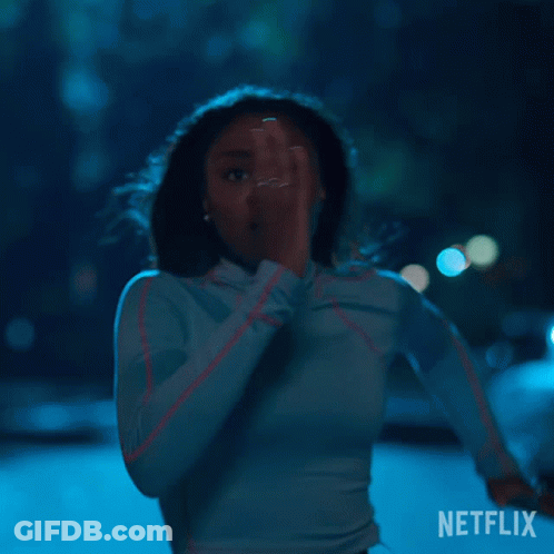 A Woman In A Blue Shirt Is Running In The Dark With A Netflix Logo In The Corner . GIF