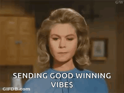 A Woman In A Blue Shirt Is Sending Good Winning Vibes To Someone . GIF