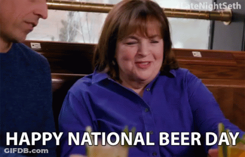A Woman In A Blue Shirt Is Sitting Next To A Man In A Restaurant And Says Happy National Beer Day GIF
