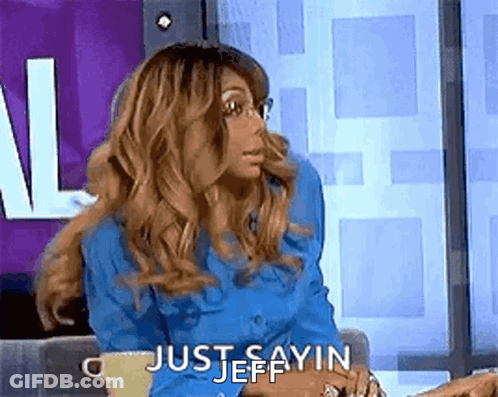 A Woman In A Blue Shirt Is Sitting On A Couch With A Cup Of Coffee And Saying `` Just Sayin Jeff '' . GIF