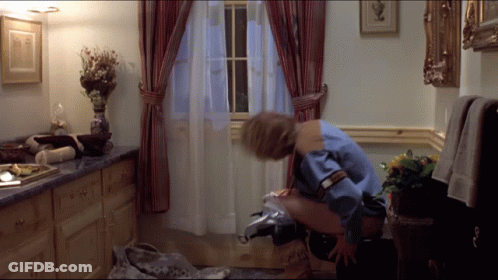 A Woman In A Blue Shirt Is Sitting On A Toilet GIF