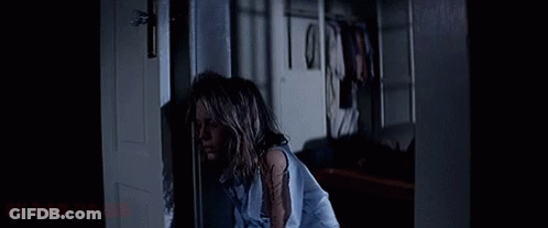 A Woman In A Blue Shirt Is Standing In A Dark Room With The Words " By Diablito " On The Bottom GIF