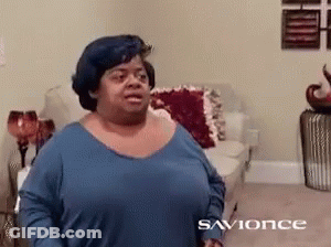 A Woman In A Blue Shirt Is Standing In A Living Room With The Word Savonce On The Bottom GIF