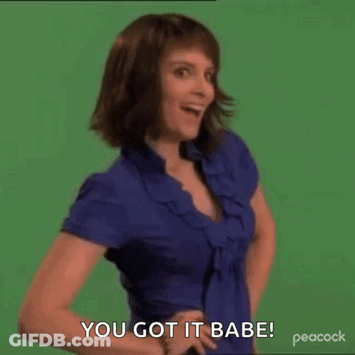 A Woman In A Blue Shirt Is Standing In Front Of A Green Screen With Her Hands On Her Hips . GIF