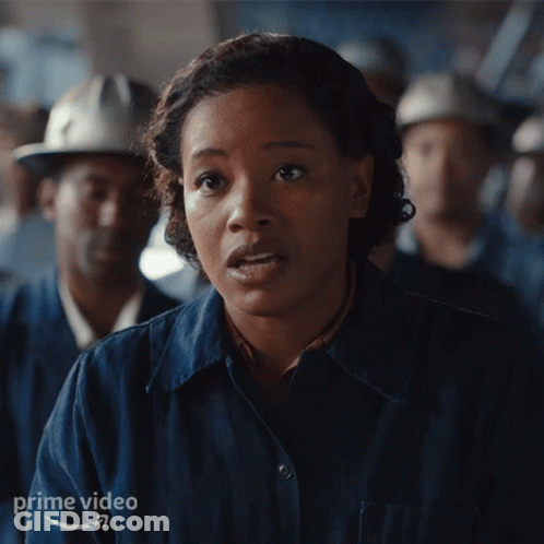 Woman In Blue Shirt In Front Of Men With Hard Hats GIF