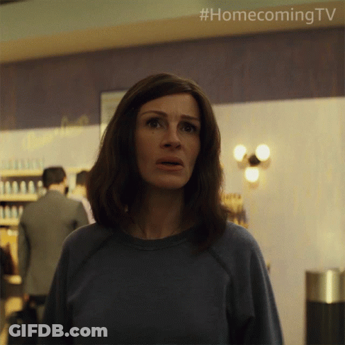A Woman In A Blue Shirt Is Standing In Front Of A Wall That Says Homecoming Tv GIF