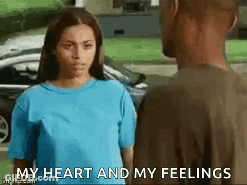 A Woman In A Blue Shirt Is Standing Next To A Man In A Brown Shirt And Saying `` My Heart And My Feelings '' . GIF