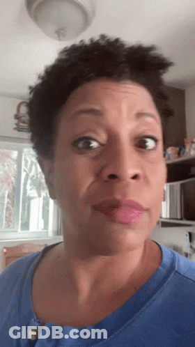 A Woman In A Blue Shirt Looks At The Camera GIF