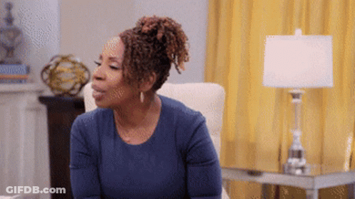 A Woman In A Blue Shirt Sits In A Chair GIF