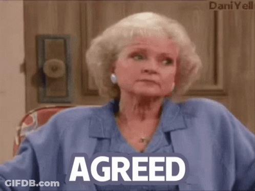 A Woman In A Blue Shirt With The Word Agreed On Her Chest GIF