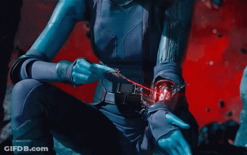 A Woman In A Blue Suit Holds A Red Object In Her Hand GIF