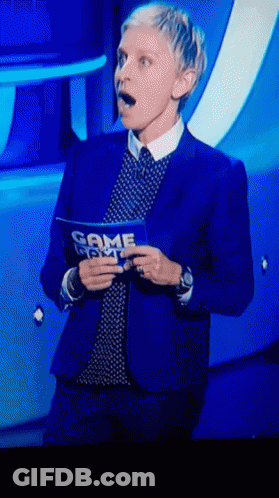 A Woman In A Blue Suit Is Holding A Sign That Says Game Night GIF