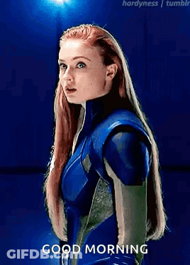 A Woman In A Blue Suit Is Standing In Front Of A Blue Background And Says Good Morning . GIF