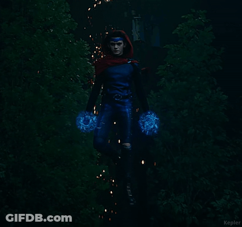 A Woman In A Blue Superhero Costume Is Holding A Blue Object In Her Hands GIF