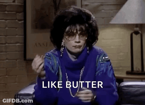 A Woman In A Blue Sweater Is Sitting On A Couch Eating A Piece Of Butter . GIF