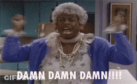 A Woman In A Blue Sweater Is Standing In A Kitchen With Her Arms Outstretched . GIF