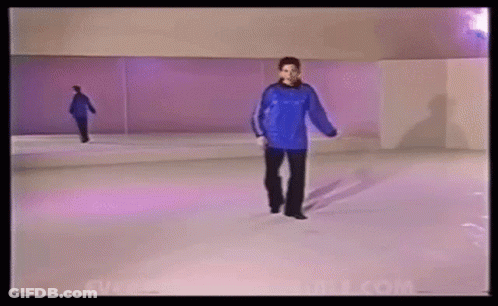 A Woman In A Blue Sweater Is Walking On A White Ice Rink . GIF