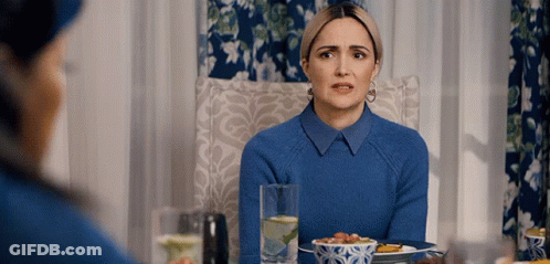 A Woman In A Blue Sweater Sits At A Table With A Plate Of Food GIF