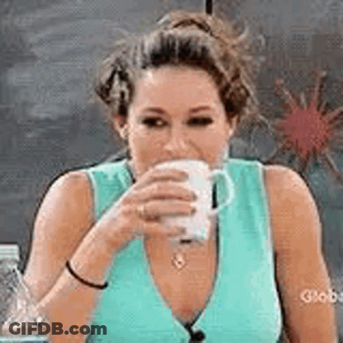 A Woman In A Blue Tank Top Is Drinking From A Cup . GIF