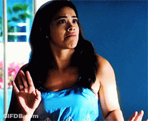 A Woman In A Blue Tank Top Is Making A Face GIF
