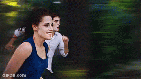 A Woman In A Blue Tank Top Is Running With A Man In A White Shirt GIF