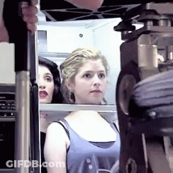 A Woman In A Blue Tank Top Looks At Something GIF