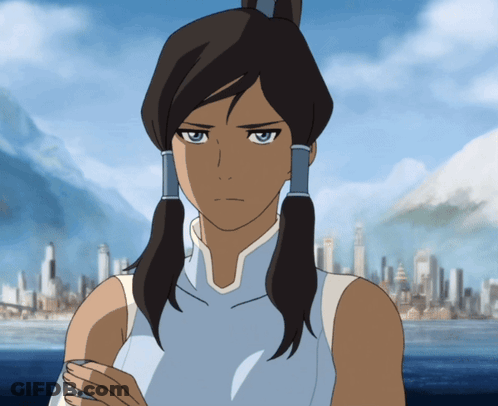 A Woman In A Blue Tank Top Stands In Front Of A City With Mountains In The Background GIF