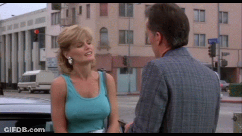 A Woman In A Blue Tank Top Talks To A Man GIF
