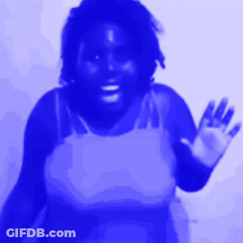 A Woman In A Blue Tank Top Waves Her Hand GIF