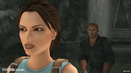 A Woman In A Blue Top Is Standing Next To A Man In A Black Jacket With The Letter B On The Back GIF