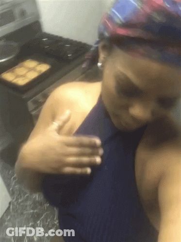 A Woman In A Blue Top Is Taking A Selfie GIF