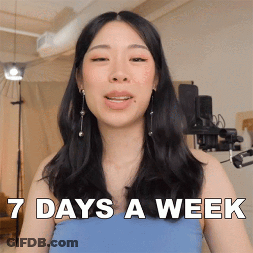 A Woman In A Blue Top Says 7 Days A Week In White Letters GIF
