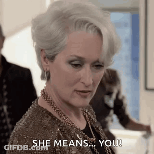 A Woman In A Brown Dress Is Saying She Means You ! GIF