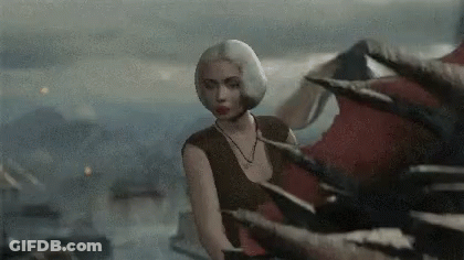 A Woman In A Brown Top Stands In Front Of A Dragon 'S Tail GIF