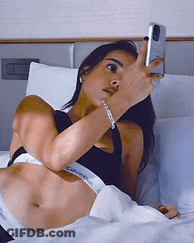 A Woman In A Calvin Klein Underwear Is Taking A Picture Of Herself GIF