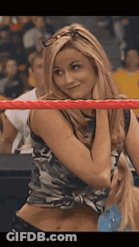 A Woman In A Camo Top Is Standing In A Wrestling Ring GIF