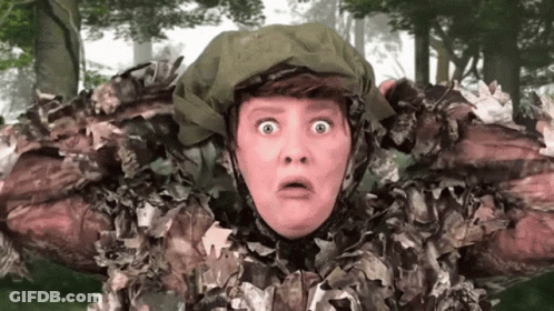 A Woman In A Camouflage Outfit Has A Surprised Look On Her Face . GIF