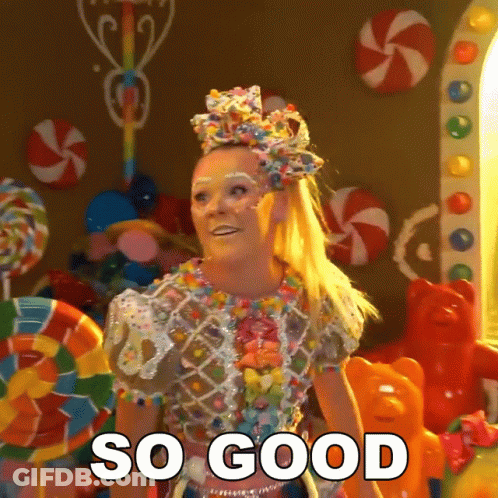 A Woman In A Candy Costume Says So Good In Front Of Candy GIF