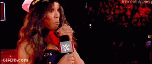 A Woman In A Captain 'S Hat Is Holding A Microphone In Front Of A Crowd . GIF