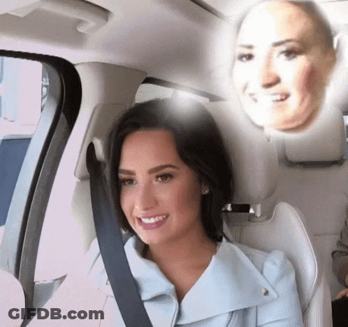 A Woman In A Car With A Reflection Of Her Face On The Back Seat GIF